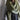 Person wearing a large green knitted scarf against a neutral background